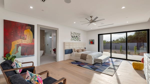 Light-filled primary suite with expansive windows, wood flooring, and direct access to outdoor living. This Paradise Valley home emphasizes indoor-outdoor lifestyle and modern comfort.
