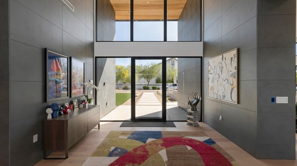 Dramatic entry with tall ceilings, glass doors, and modern architectural lines. This Paradise Valley home creates a welcoming yet sophisticated first impression.