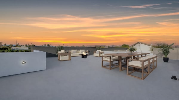 Virtually staged sky deck showcasing outdoor dining and lounge areas with panoramic views. This Paradise Valley home offers a unique rooftop space ideal for entertaining.