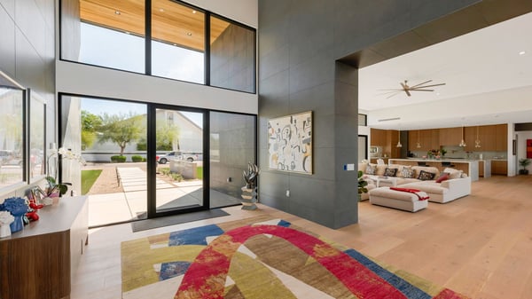 Grand entryway with tall glass doors and sleek architectural details. This Paradise Valley home creates a bold and elegant first impression.