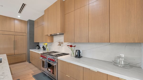 Contemporary kitchen with custom wood cabinetry, quartz surfaces, and high-end appliances. This Paradise Valley home delivers style, storage, and functionality.