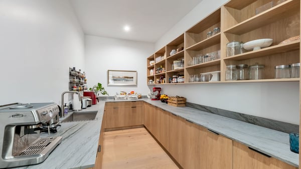 Functional pantry with open shelving, prep counter, and ample storage. This Paradise Valley home is designed for efficiency and modern living.