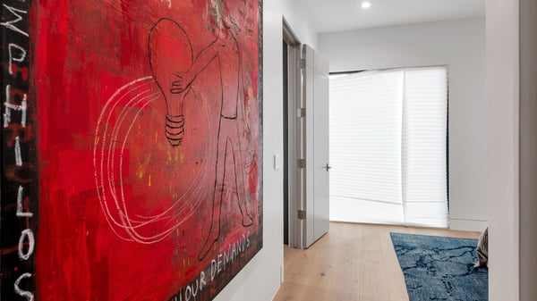 Interior hallway featuring clean architecture, wood floors, and bold artwork. This Paradise Valley home emphasizes modern design and open flow.