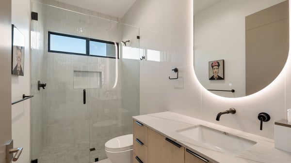 Bathroom with sleek vanity, glass shower, and contemporary lighting. This Paradise Valley home showcases updated fixtures and modern style.