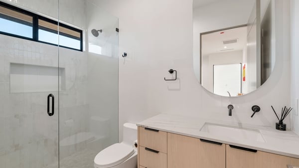 Modern full bathroom with glass shower, vanity storage, and sleek finishes. This Paradise Valley home offers upgraded bathrooms throughout.