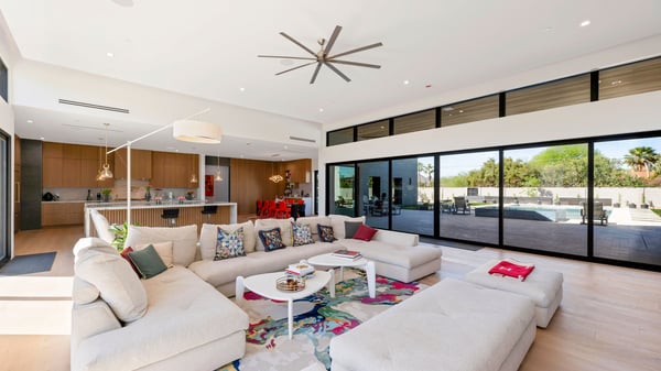Bright open living space with full wall of glass showcasing the backyard and pool. This Paradise Valley home offers a perfect blend of comfort and luxury.