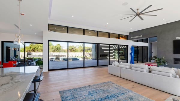 Large great room combining living, kitchen, and dining areas with modern finishes and high ceilings. This Paradise Valley home features a desirable open floor plan.