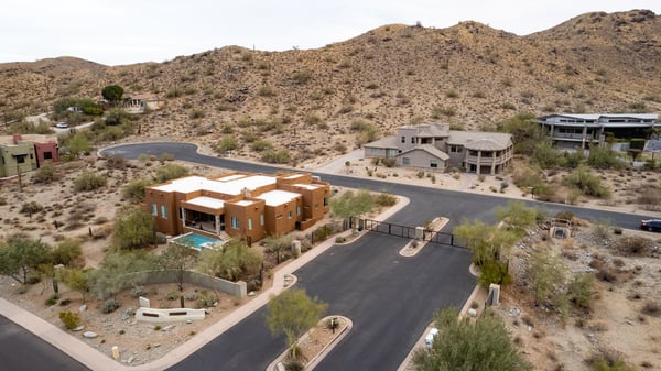 Secure gated entrance welcomes residents into an upscale hillside neighborhood surrounded by luxury custom homes and scenic desert landscapes near South Mountain Preserve.