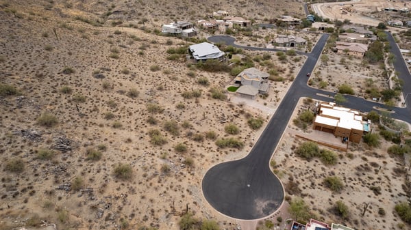 Expansive aerial view of this premium hillside lot surrounded by custom homes and breathtaking desert scenery. An ideal Phoenix location for building a luxury residence with mountain views.