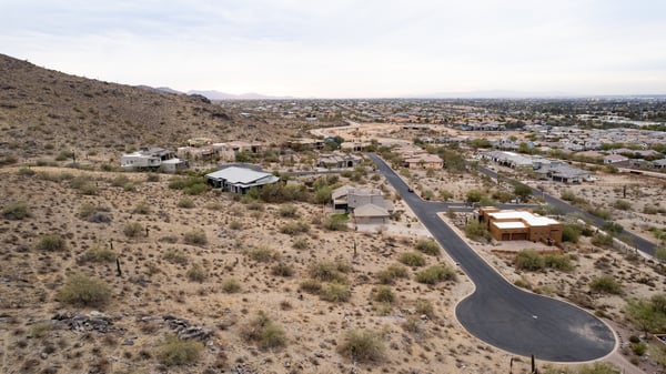 Exceptional aerial perspective showcasing the property s elevated setting among scenic desert terrain and luxury homes. Build your dream residence surrounded by breathtaking Phoenix mountain views.