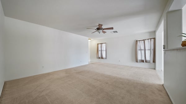 Expansive living room provides flexible furniture arrangements, abundant natural light, and easy access to the kitchen and dining area. A comfortable space designed for everyday enjoyment.
