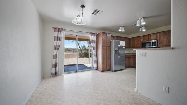 Dining area enjoys abundant natural light and sliding glass door access to the backyard, creating a pleasant setting for meals while overlooking the peaceful desert landscape and mountain views.