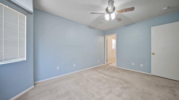 Alternate view highlights the generous proportions of the primary bedroom with easy access to the walk-in closet and private bathroom. Natural light and neutral finishes create a warm, welcoming space.