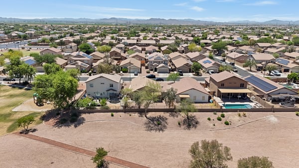 Aerial neighborhood view highlights the home's desirable setting near open space, walking paths, and surrounding Buckeye scenery while showcasing the property's convenient location.