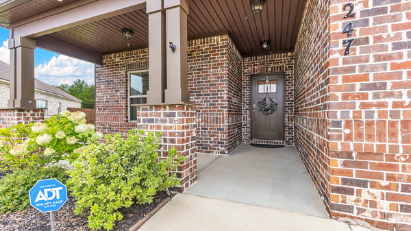 Welcoming brick façade entry with a spacious porch and well-maintained landscaping in a desirable neighborhood.