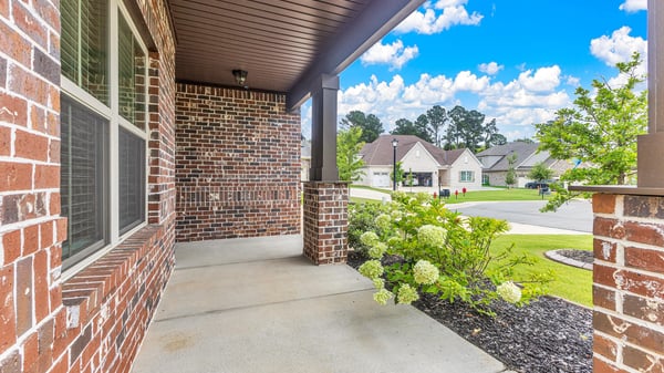 Welcoming front porch with brick accents, perfect for enjoying the neighborhood views and fresh air.