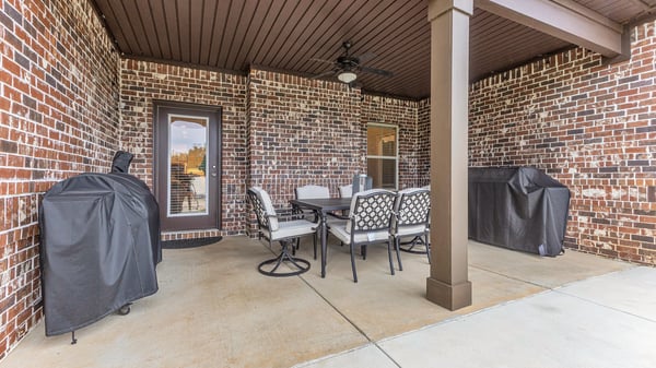Spacious covered patio offers ample seating and grill areas, perfect for entertaining and enjoying outdoor meals.