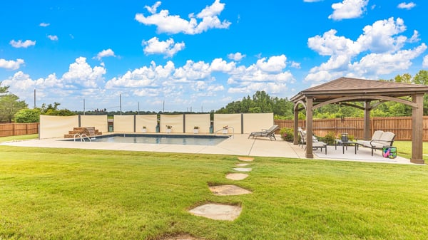 Spacious outdoor area featuring a pool, gazebo, and ample green space, perfect for entertaining.