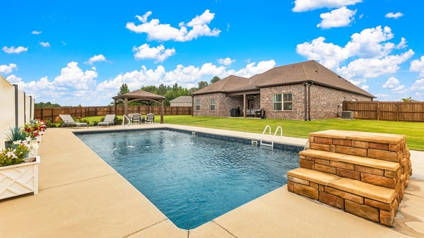 Inviting backyard oasis featuring a spacious pool, perfect for relaxation and outdoor entertaining.