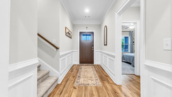 Welcoming entryway features a bright hallway with LVP floors, leading to inviting living spaces upstairs.