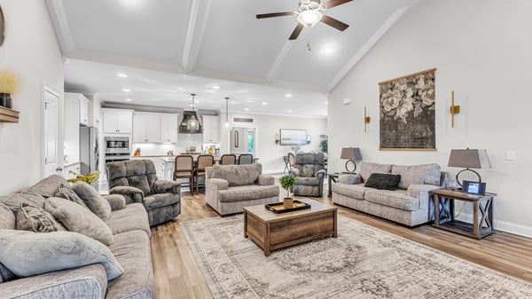 Spacious living area with vaulted ceilings, modern kitchen access, and cozy seating for family gatherings.