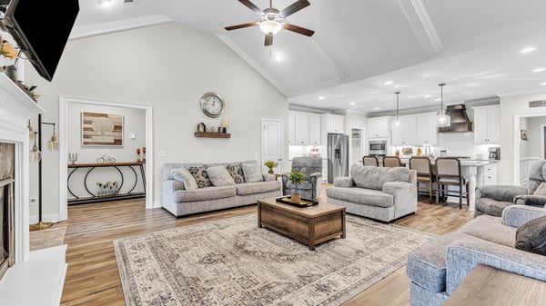 Spacious open-concept living area featuring high ceilings, modern kitchen access, and comfortable seating arrangements.