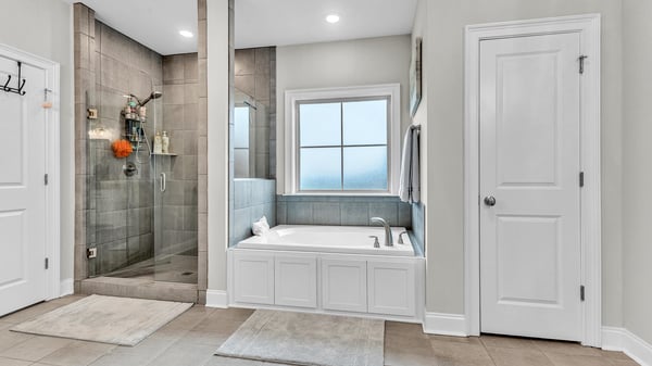 Spacious bathroom featuring a large soaking tub and a modern walk-in shower with abundant natural light.