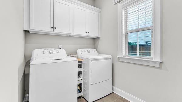Bright and functional laundry space featuring modern appliances and ample storage options for convenience.