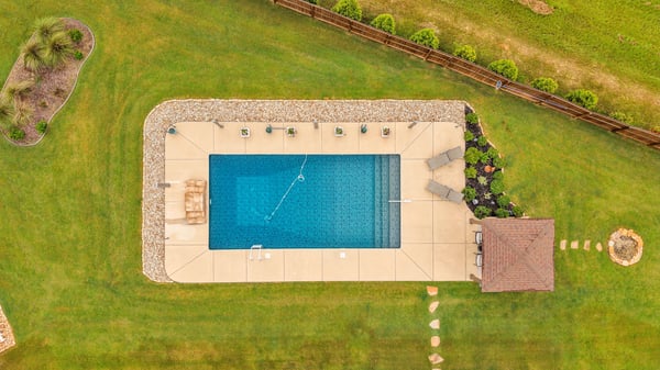 Spacious backyard featuring a pristine pool, perfect for entertaining or relaxing on sunny days.