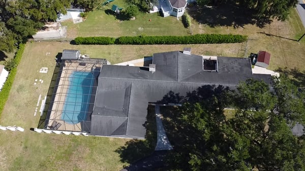 Drone view From Rear Showing property featuring 40ft x 20ft large pool, expansive lawn, and ample outdoor space for entertaining and relaxation.