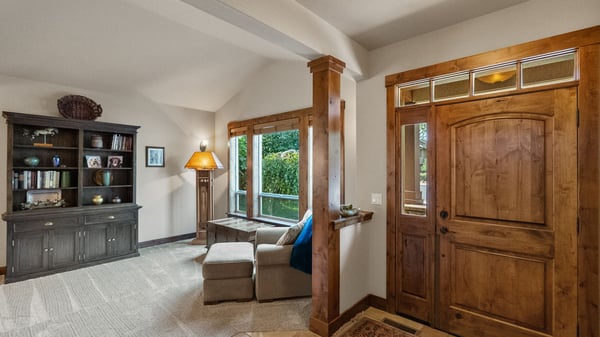 Bright entryway features large windows, inviting natural light, and a cozy seating area for relaxation.