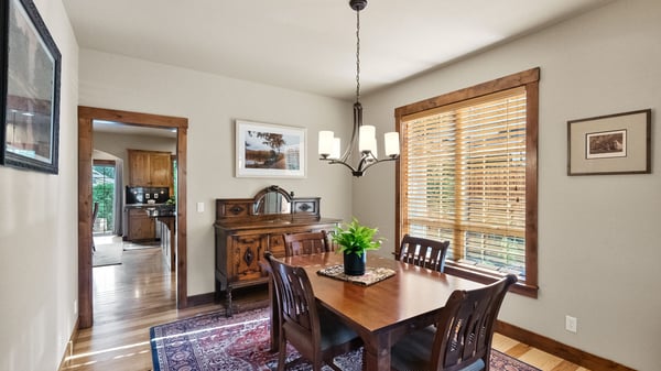 Bright dining area featuring large windows, natural light, and solid wood furniture, perfect for gatherings.
