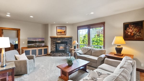 Bright and inviting living room featuring a cozy fireplace and large windows that illuminate the space.