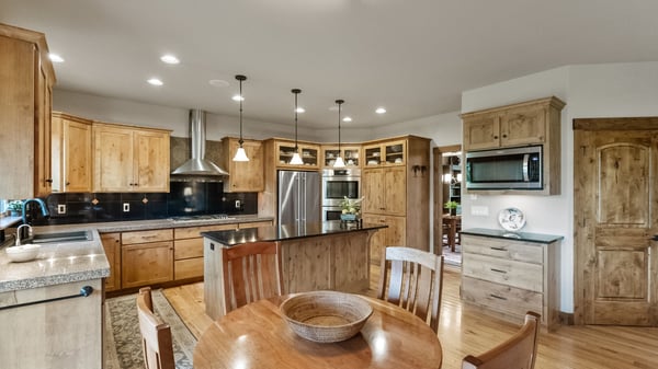 Modern kitchen featuring high-quality wood cabinetry, stainless steel appliances, and an inviting dining space.
