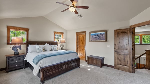 Spacious master bedroom featuring high ceilings, large windows, and ample storage in a tranquil setting.