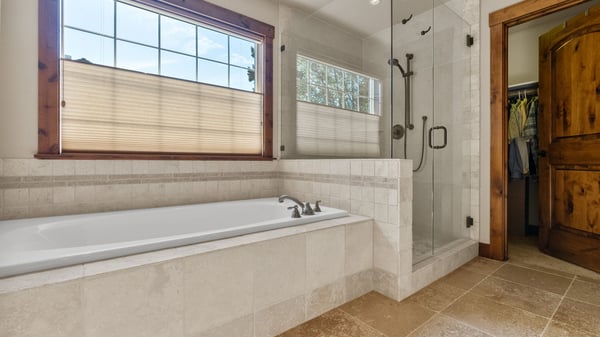 Experience modern living in this inviting bathroom, featuring a spacious soaking tub and walk-in shower.