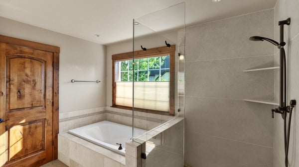 Discover this modern bathroom featuring a glass-enclosed shower, soaking tub, and natural light. Ideal for relaxation.