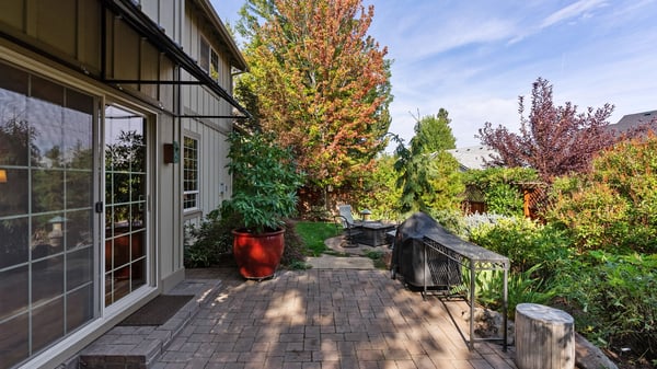 Spacious outdoor area featuring landscaped gardens and a stone patio, perfect for relaxation and gatherings.