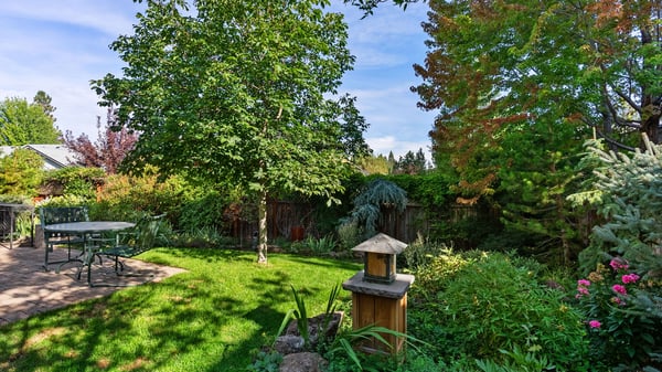 Lush garden retreat features a vibrant landscape with mature trees, perfect for outdoor gatherings and relaxation.