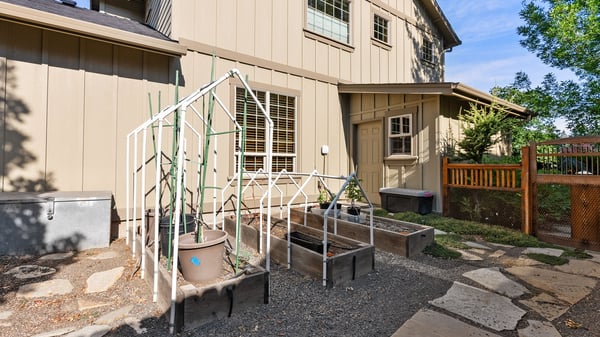 This inviting outdoor space features raised garden beds and convenient access to the home’s entrance.