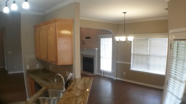 Modern open space with abundant natural light, featuring a functional kitchen and unique architectural details.