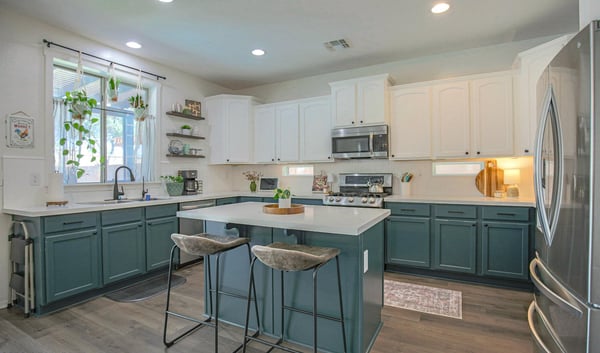 Elegant kitchen featuring quartz countertops, custom-painted cabinetry, stainless steel appliances, and a spacious island with seating. A beautifully updated centerpiece for this move-in-ready Waddell home.