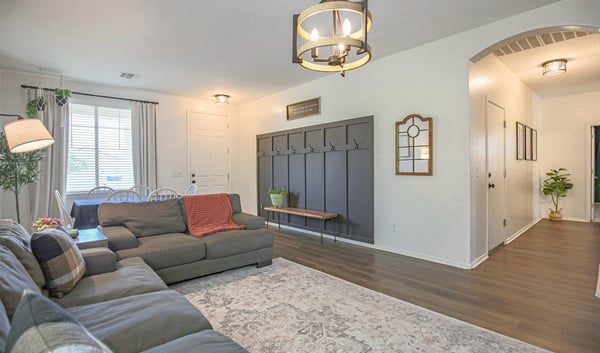 Stylish living room with luxury flooring, contemporary lighting, and a custom entry drop zone that adds organization and charm. A functional and inviting space for everyday living.