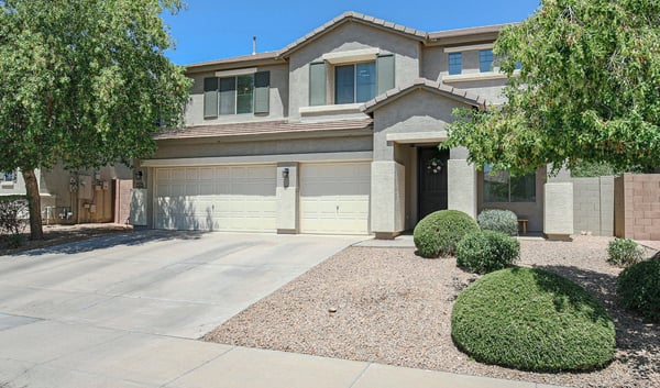 Well-maintained front exterior highlighting mature landscaping, covered entrance, and a spacious 3-car garage. This beautiful Waddell home offers lasting curb appeal.