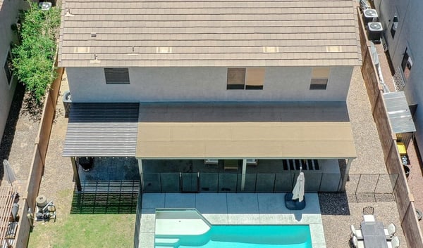 Incredible aerial perspective highlighting the sparkling pool, covered patio, custom pergola, grassy yard, and thoughtfully designed outdoor living spaces that make this Waddell home truly exceptional.