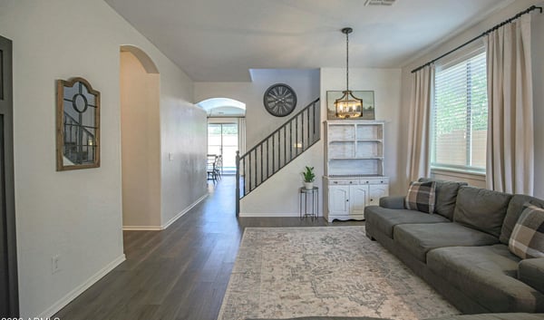 Comfortable living room with updated flooring, elegant lighting, and an open floor plan that creates a warm and welcoming atmosphere for everyday living and entertaining.