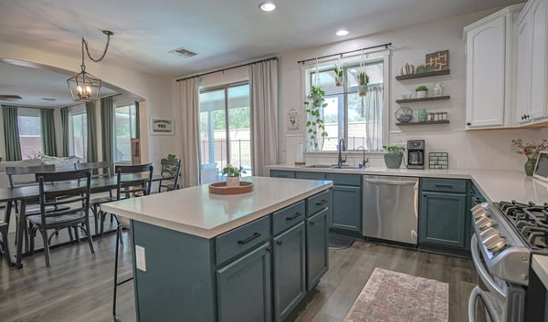 Beautifully updated kitchen featuring abundant cabinetry, quartz countertops, stainless steel appliances, and an open layout connecting effortlessly to the dining room and outdoor living areas.