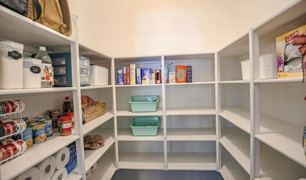 Oversized walk-in pantry with extensive built-in shelving and abundant storage, providing excellent organization for food, cookware, and household essentials just steps from the updated kitchen.