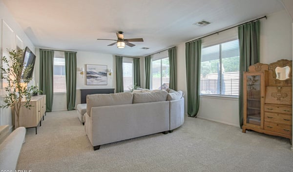 Bright family room filled with natural light from oversized windows, offering generous space for comfortable seating and effortless connection to the rest of this beautifully maintained Waddell home.