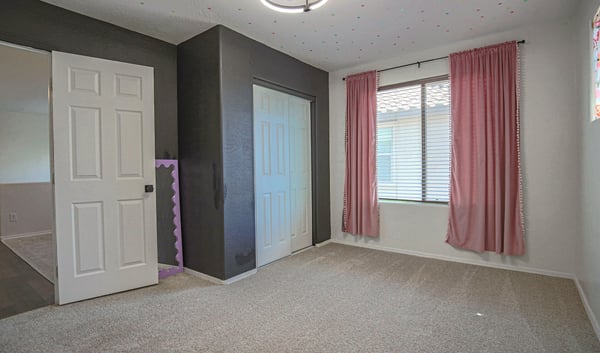 Bright secondary bedroom with soft carpeting, a large window, and convenient closet storage. This versatile room is perfect for a nursery, guest bedroom, playroom, or home office.